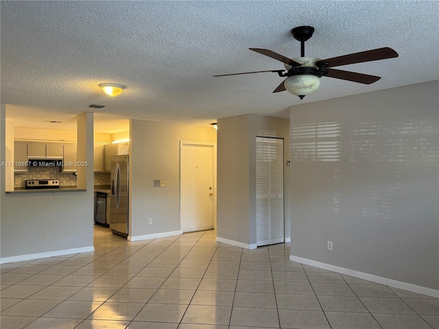 tiled spare room with ceiling fan