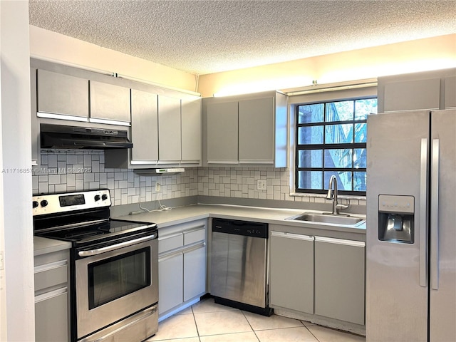 kitchen featuring appliances with stainless steel finishes, a textured ceiling, ventilation hood, sink, and light tile patterned floors