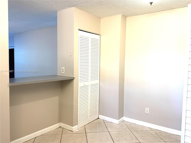 hallway featuring light tile patterned flooring and a textured ceiling