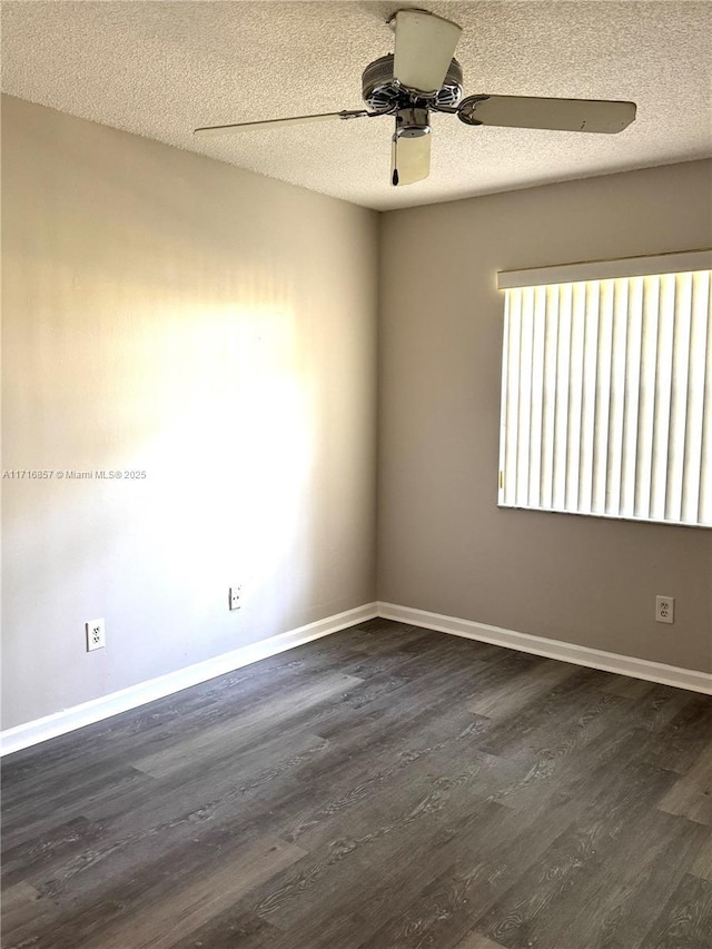 spare room with a textured ceiling, ceiling fan, and dark wood-type flooring