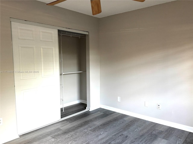 unfurnished bedroom featuring dark hardwood / wood-style floors, ceiling fan, and a closet