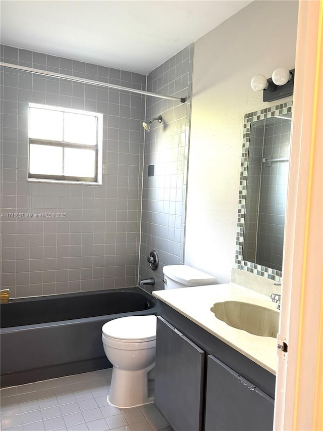 full bathroom with tile patterned flooring, vanity, tiled shower / bath combo, and toilet