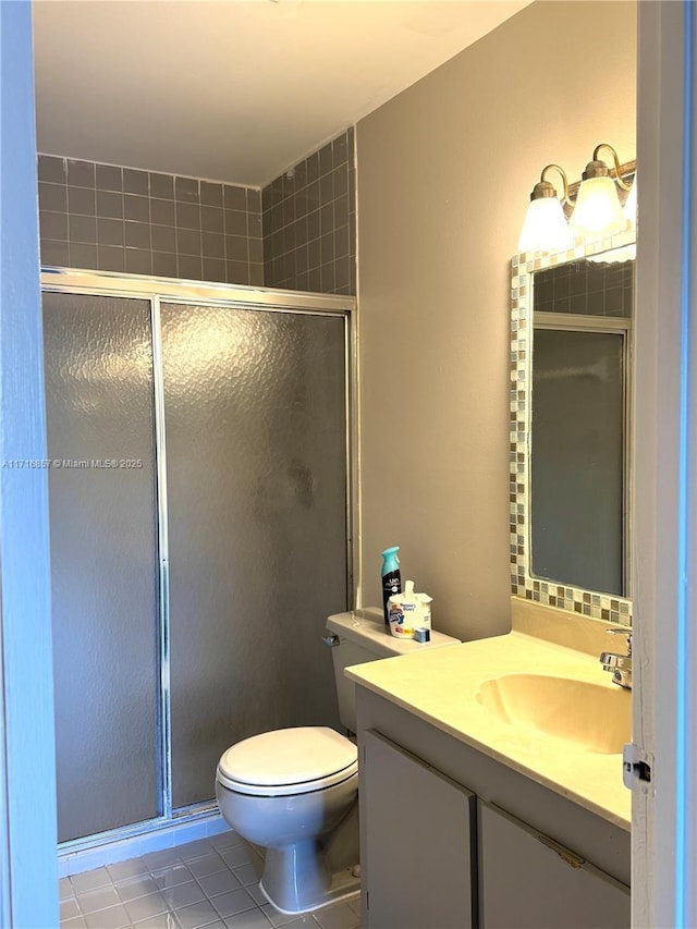 bathroom with tile patterned flooring, vanity, toilet, and walk in shower