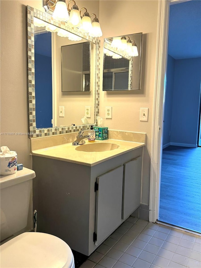 bathroom with tile patterned flooring, vanity, and toilet