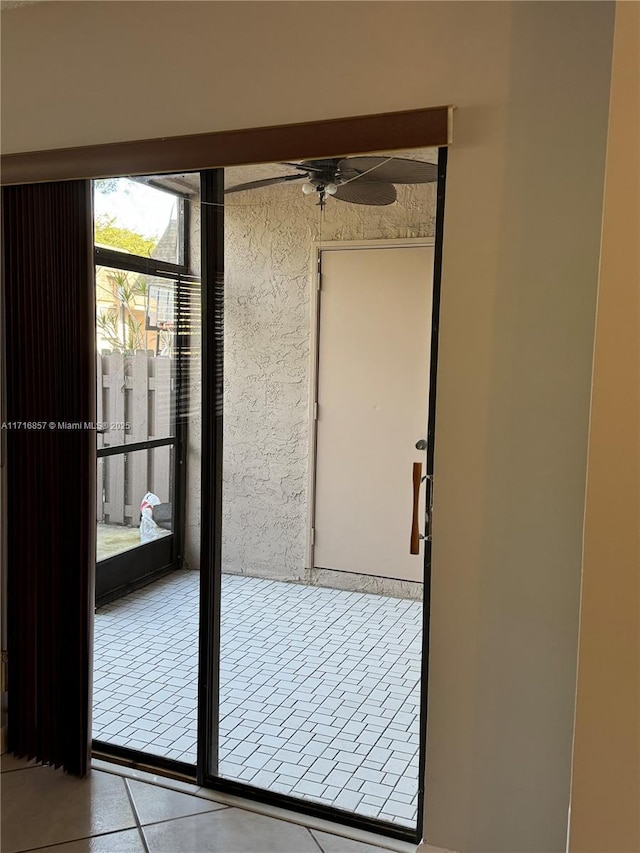 entryway featuring light tile patterned floors and ceiling fan