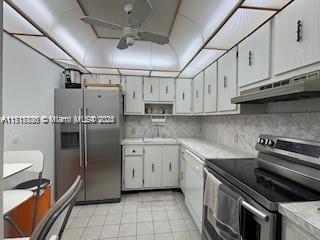 kitchen featuring ceiling fan, sink, light tile patterned floors, white cabinets, and appliances with stainless steel finishes