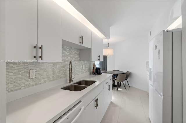 kitchen with pendant lighting, white cabinets, sink, light tile patterned floors, and tasteful backsplash