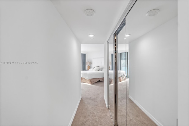 hallway featuring light colored carpet