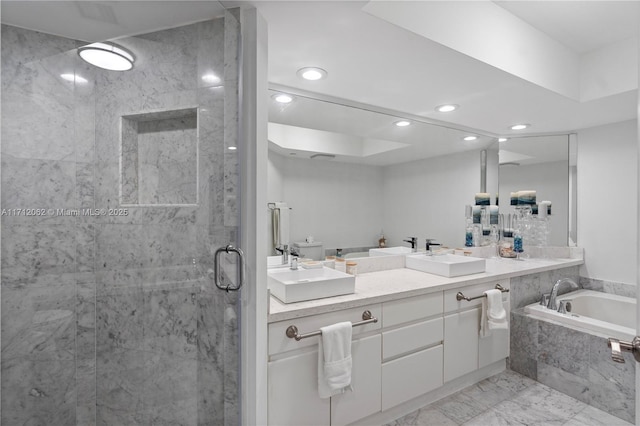 bathroom featuring vanity and independent shower and bath