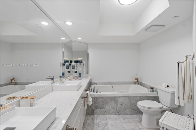 bathroom with vanity, tiled bath, and toilet