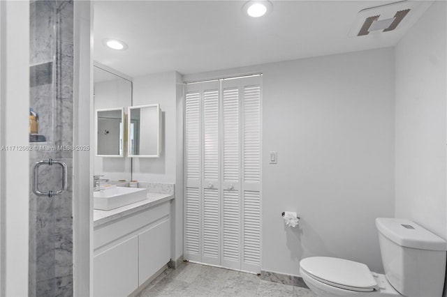 bathroom with an enclosed shower, vanity, and toilet