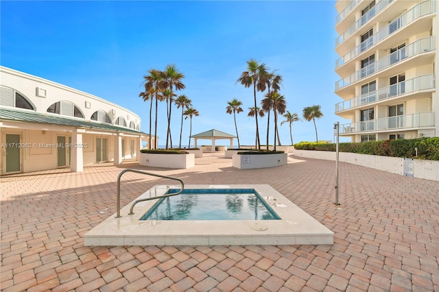 view of swimming pool with a hot tub