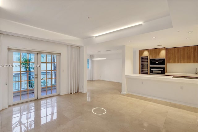 kitchen featuring multiple ovens, french doors, and sink