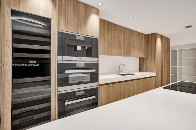 kitchen featuring black double oven and sink