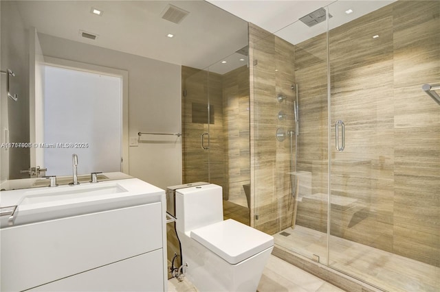 bathroom with tile patterned floors, vanity, toilet, and a shower with door