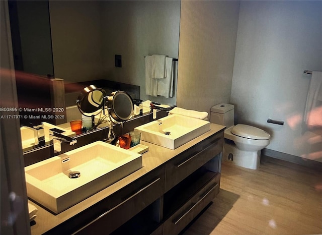 bathroom featuring vanity, hardwood / wood-style floors, and toilet