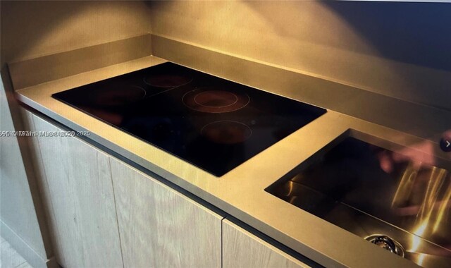 room details featuring black electric stovetop, cooktop, and light brown cabinets