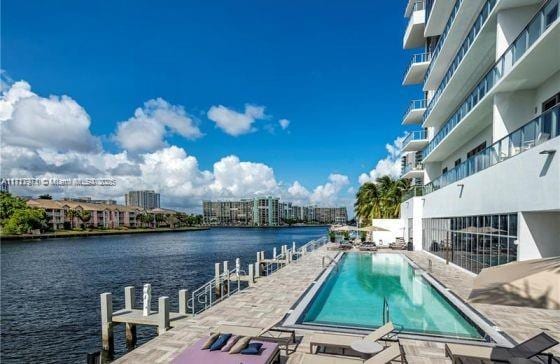 view of swimming pool featuring a patio area and a water view