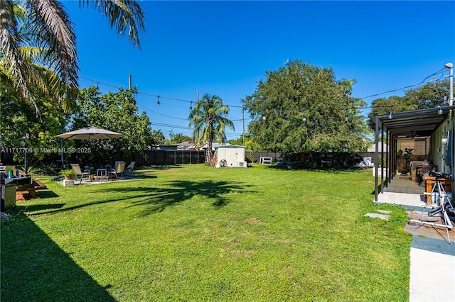 view of yard featuring an outdoor fire pit and a storage shed