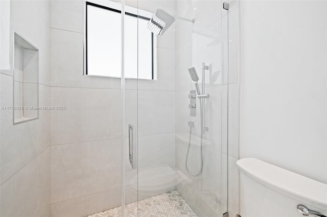 bathroom featuring toilet and an enclosed shower