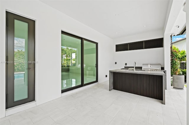 view of patio / terrace featuring a grill, sink, and exterior kitchen