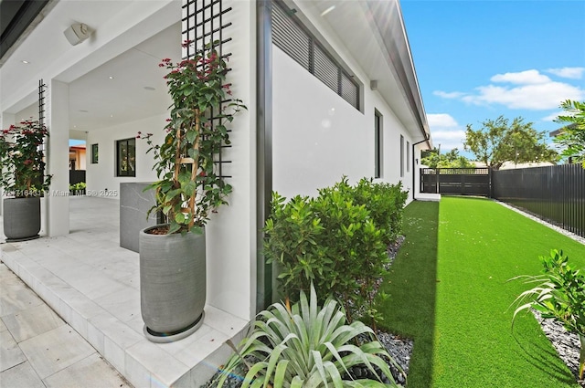 view of home's exterior with a lawn and a patio area