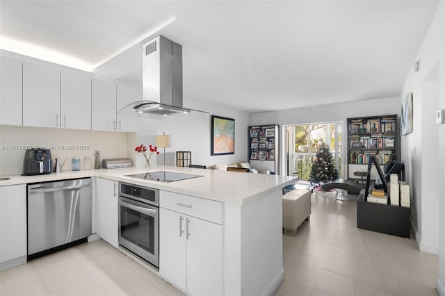 kitchen featuring kitchen peninsula, wall chimney exhaust hood, and appliances with stainless steel finishes