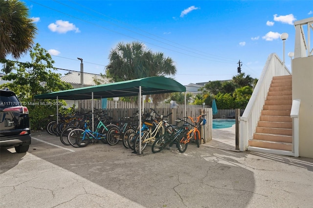 view of parking with a fenced in pool