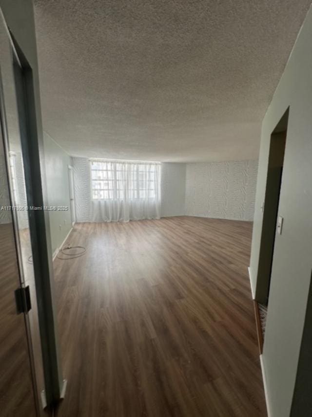 unfurnished room with dark hardwood / wood-style flooring, expansive windows, and a textured ceiling