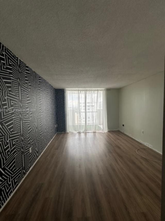 spare room with hardwood / wood-style floors and a textured ceiling