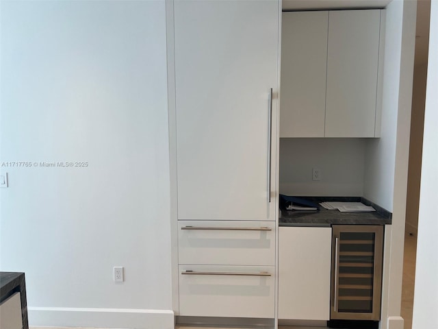 kitchen with wall oven, white cabinetry, and wine cooler