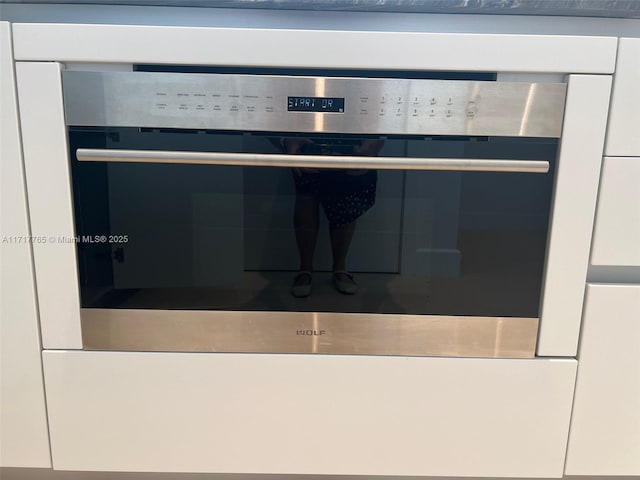 room details featuring white cabinets and stainless steel oven