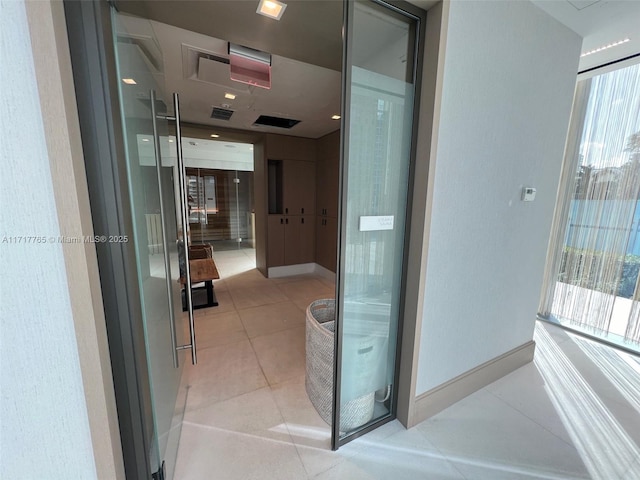 hall featuring a wealth of natural light and light tile patterned floors