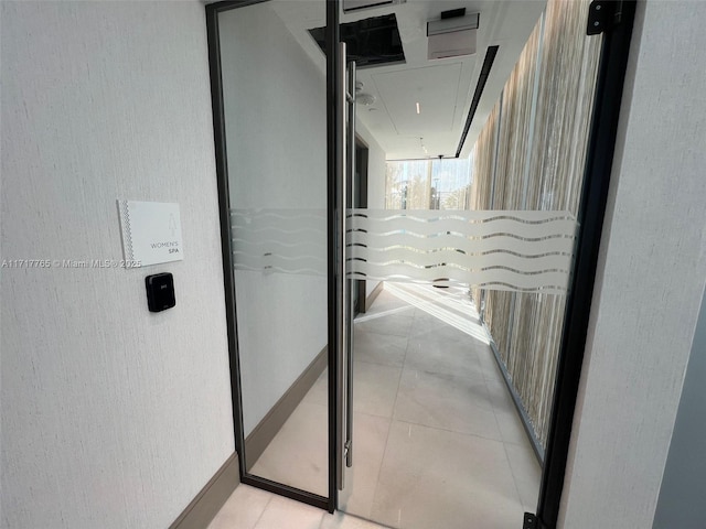 700 NE 26th Ter Unit 2004, Miami, FL 33137 - corridor featuring attic access, elevator, light tile patterned floors, and a textured wall