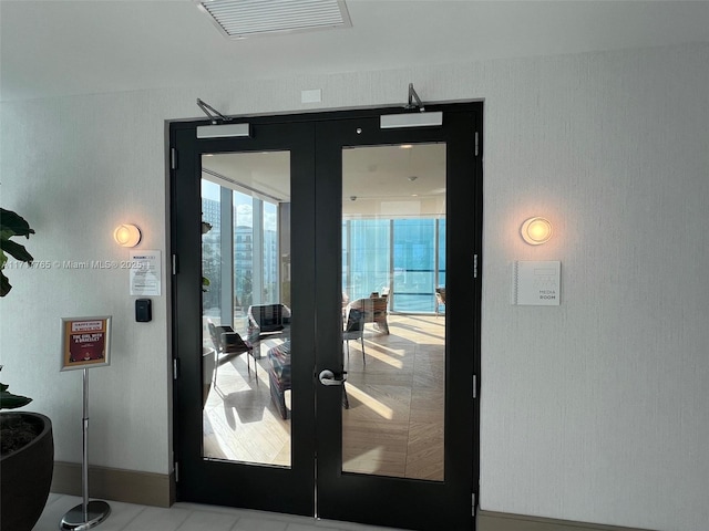 doorway to outside with french doors and light tile patterned flooring