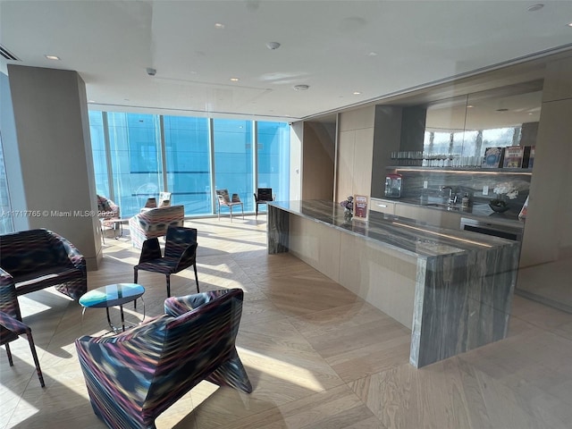 kitchen with expansive windows, sink, and dark stone counters