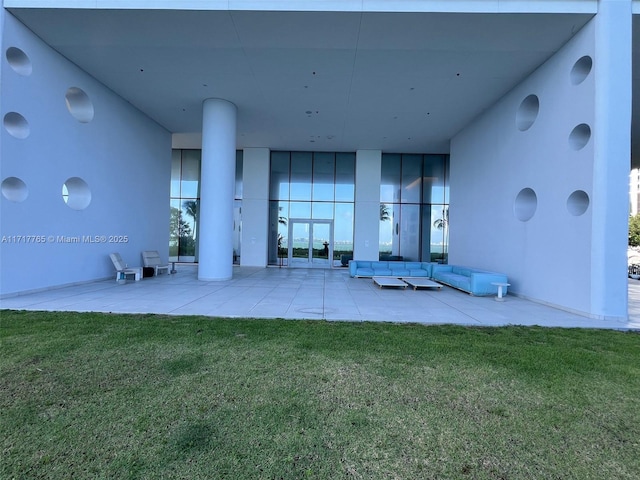 rear view of house with a patio and a lawn