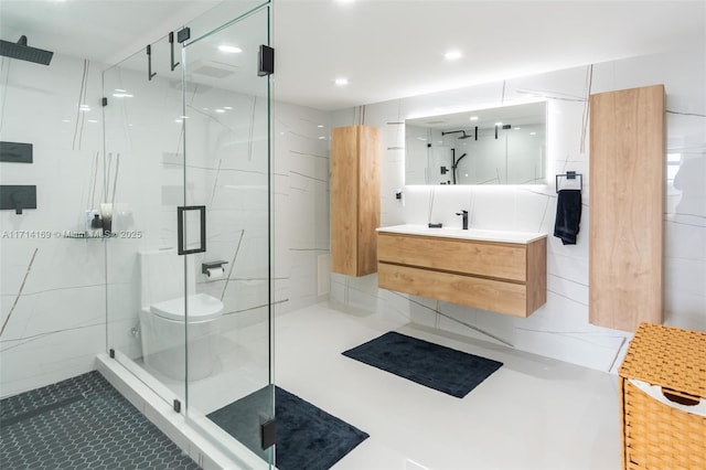 bathroom with vanity, toilet, a shower with shower door, and tile patterned flooring