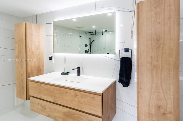 bathroom featuring vanity and tile walls