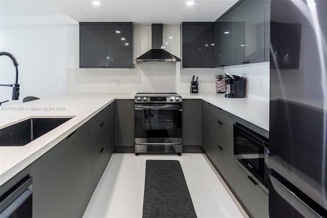 kitchen featuring stainless steel appliances, sink, wall chimney range hood, and gray cabinetry