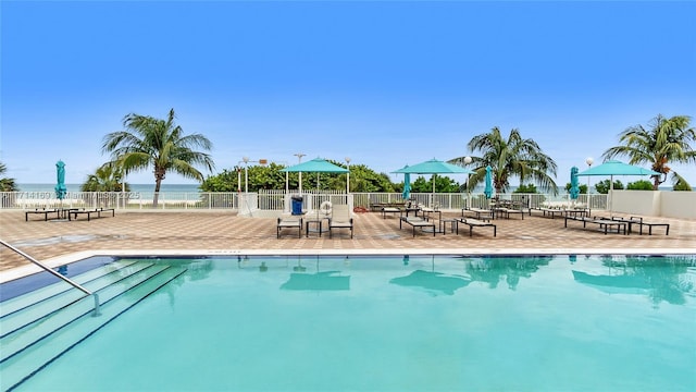 view of pool with a patio area and a water view