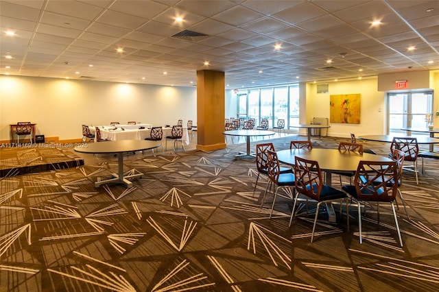 carpeted dining area featuring a healthy amount of sunlight and a drop ceiling