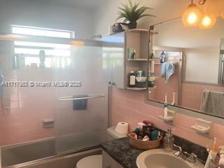 full bathroom with vanity, toilet, and bath / shower combo with glass door