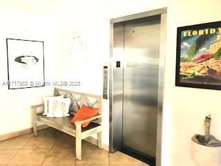 corridor with elevator and light tile patterned flooring