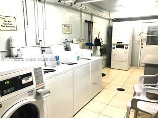 clothes washing area featuring light tile patterned flooring and washer and dryer