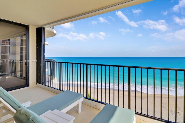 balcony featuring a beach view and a water view