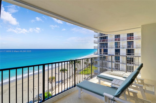 balcony featuring a water view and a beach view