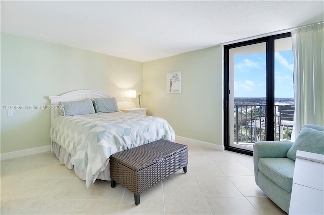 bedroom with floor to ceiling windows, access to exterior, light tile patterned floors, and multiple windows