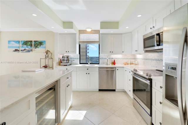 kitchen featuring stainless steel appliances, beverage cooler, sink, white cabinets, and light tile patterned flooring