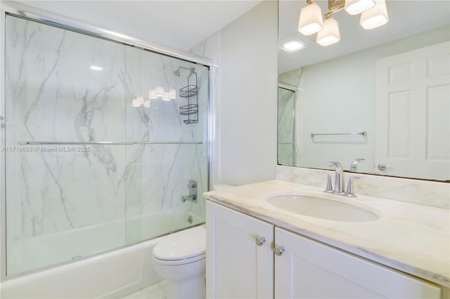 full bathroom featuring vanity, enclosed tub / shower combo, and toilet